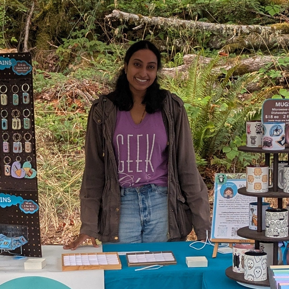 A photo of the artist, Sneha, at her booth at a market